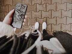 Handy in der Hand mit eingesteckten Kopfhörern